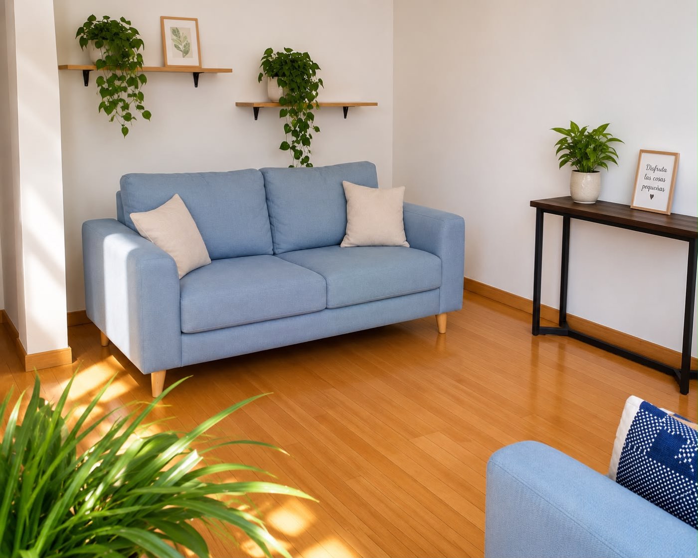 Sala de espera del consultorio, luminosa y cálida, con plantas y sillones azules